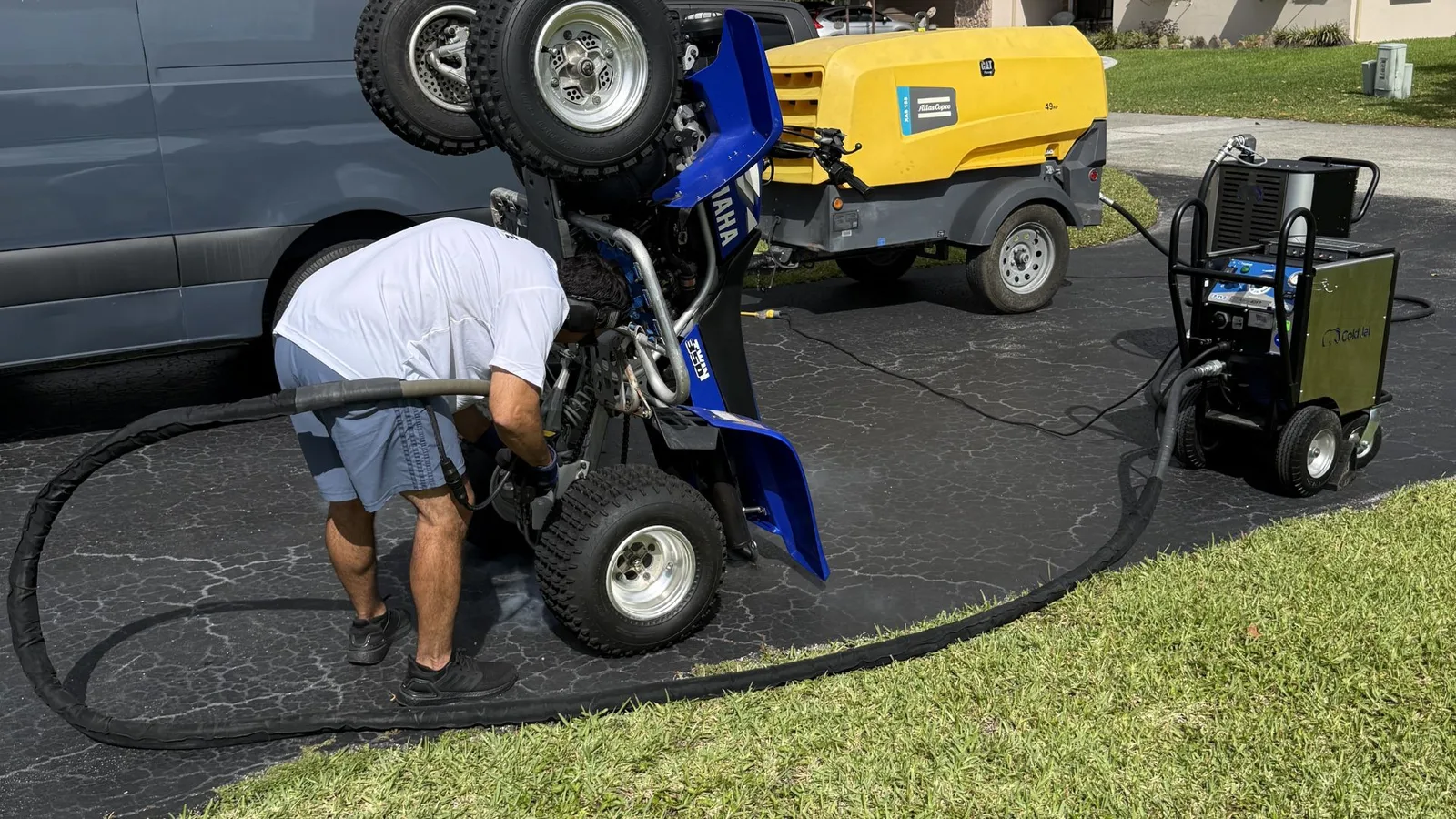 Blasting the frame of a quad, compressor in the background