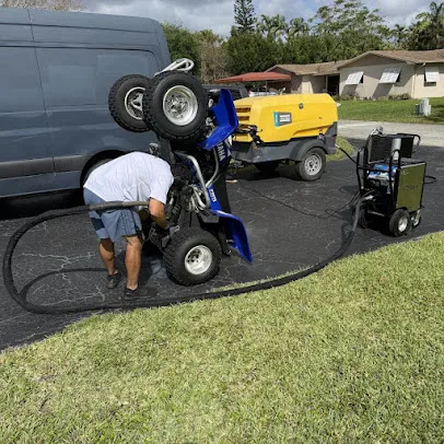 A quad tipped up beside the van and compressor