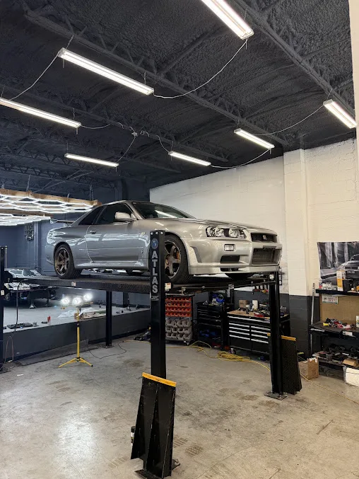 A Nissan Skyline R34 on a lift in the workshop